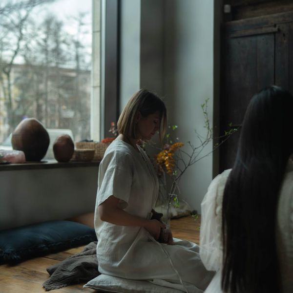 Woman meditating peacefully in a minimalist setting.